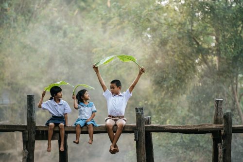 Asian children sitting and play with banana leaves